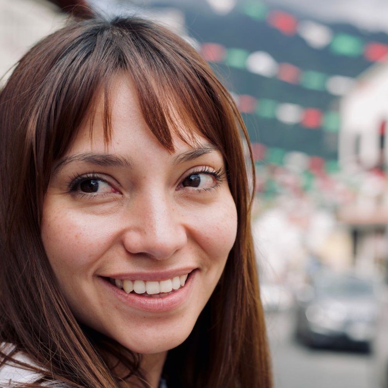 Woman with brown hair and bangs smiling