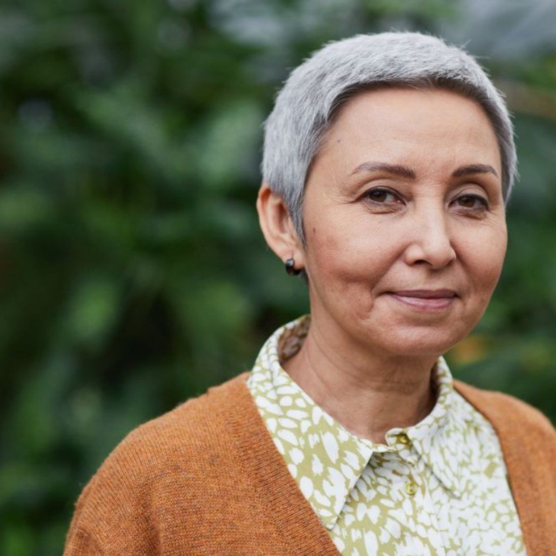 Woman with short silver hair and a warm expression